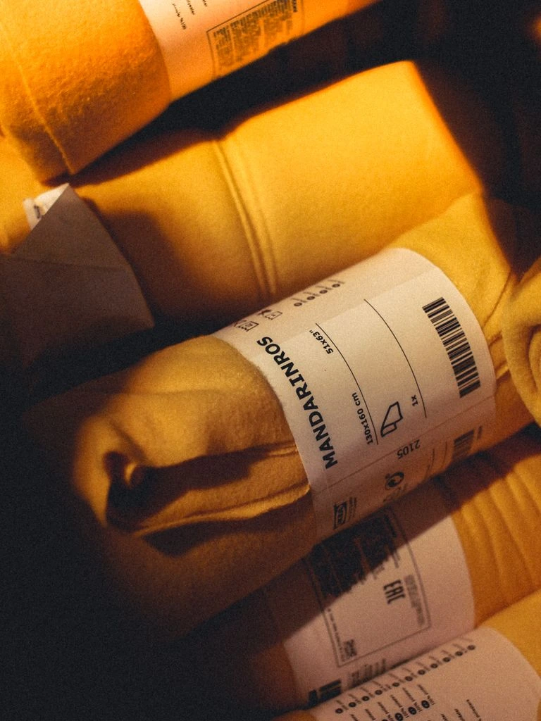 Stacks of warm-cream postcards wait on a fulfillment table under window light.